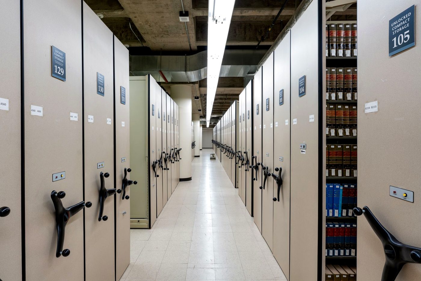 A long aisle of compact shelving in a records archive.