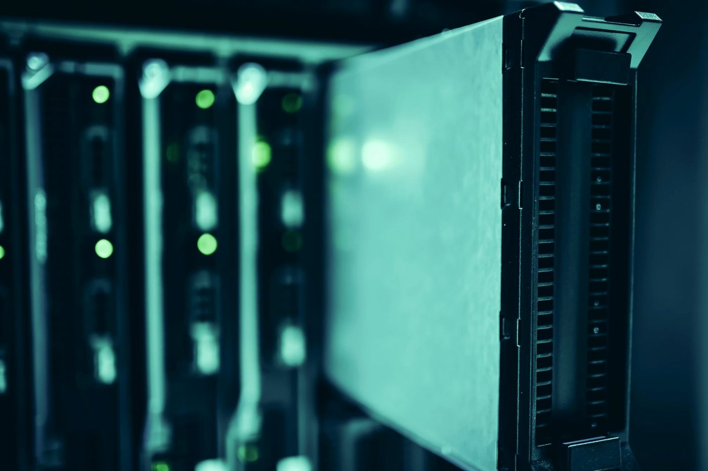 A row of illuminated server racks in a data centre aisle.