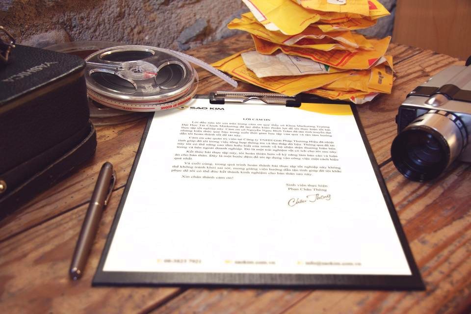 A signed document on a clipboard resting on a wooden desk.