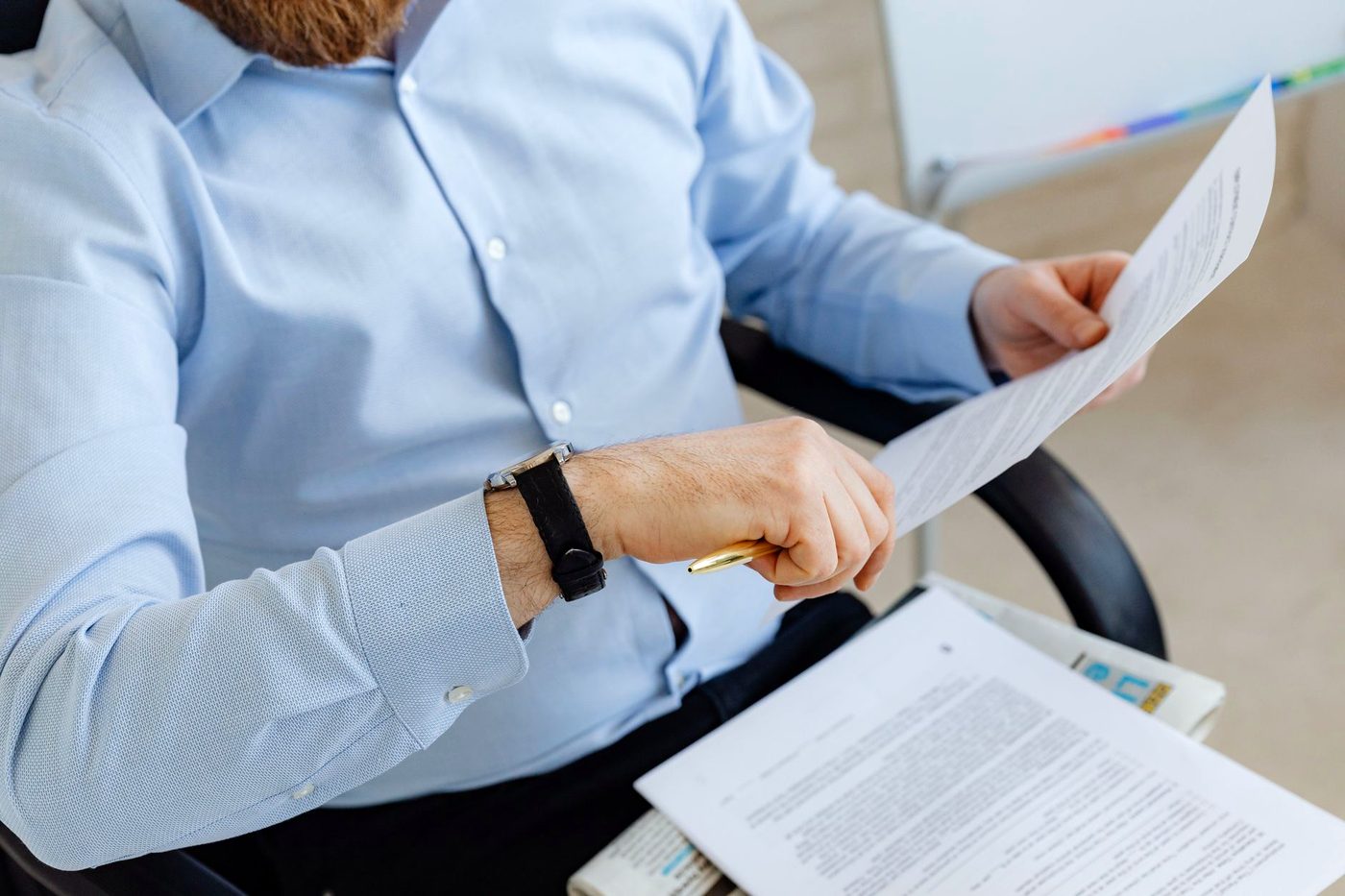 Two people at a desk comparing printed documents side by side.