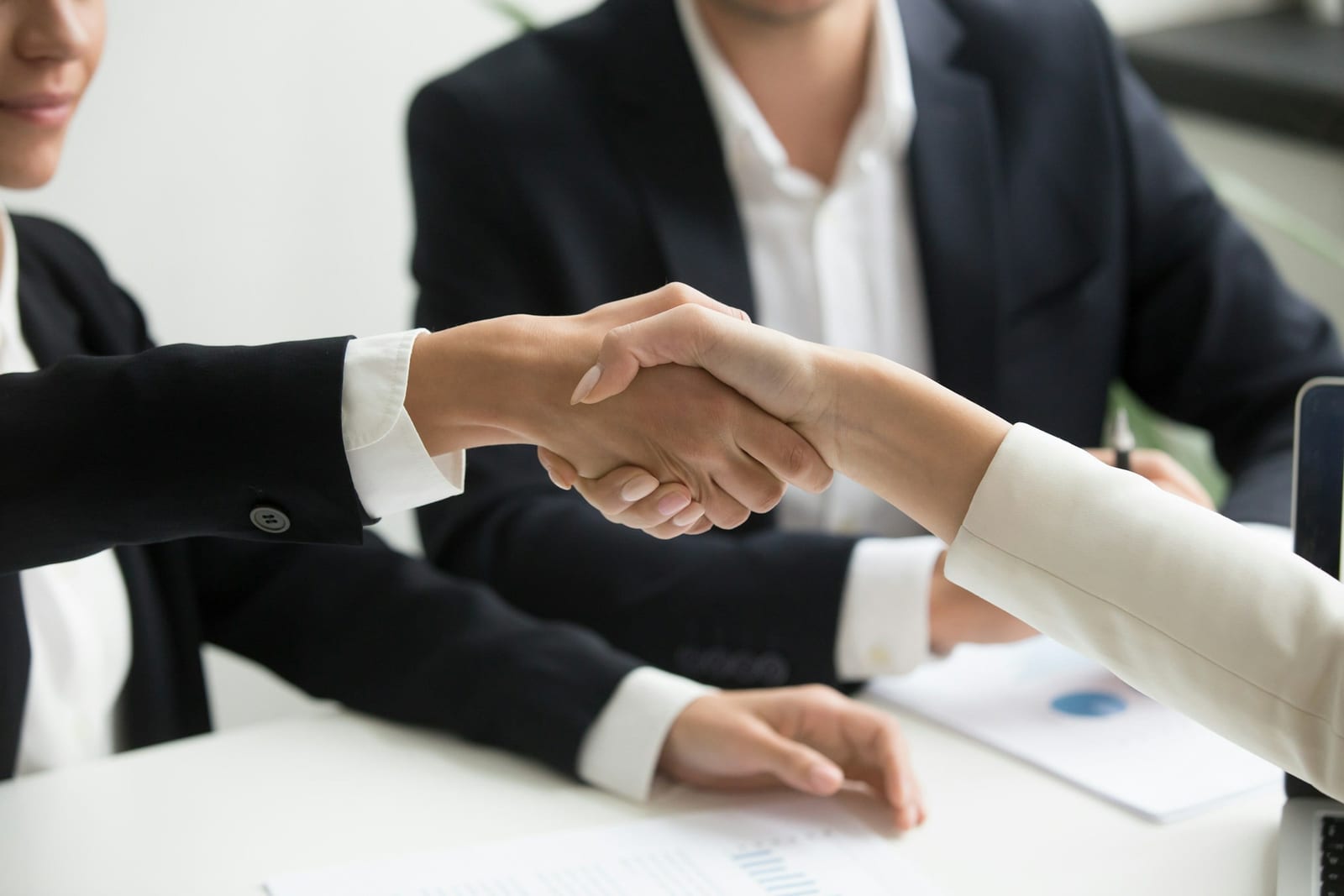 Two IT professionals completing a client handoff across a desk.